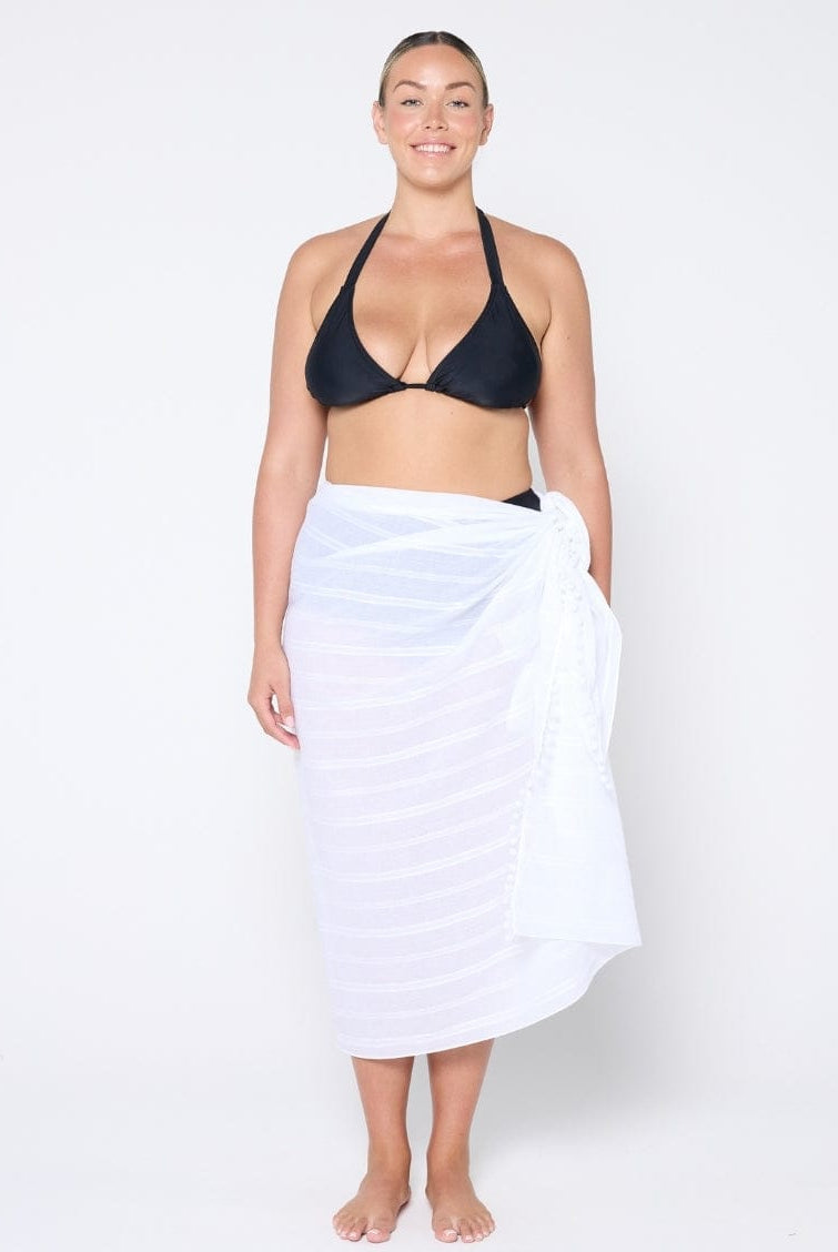 model standing in front of a white wall wearing a white cotton sarong