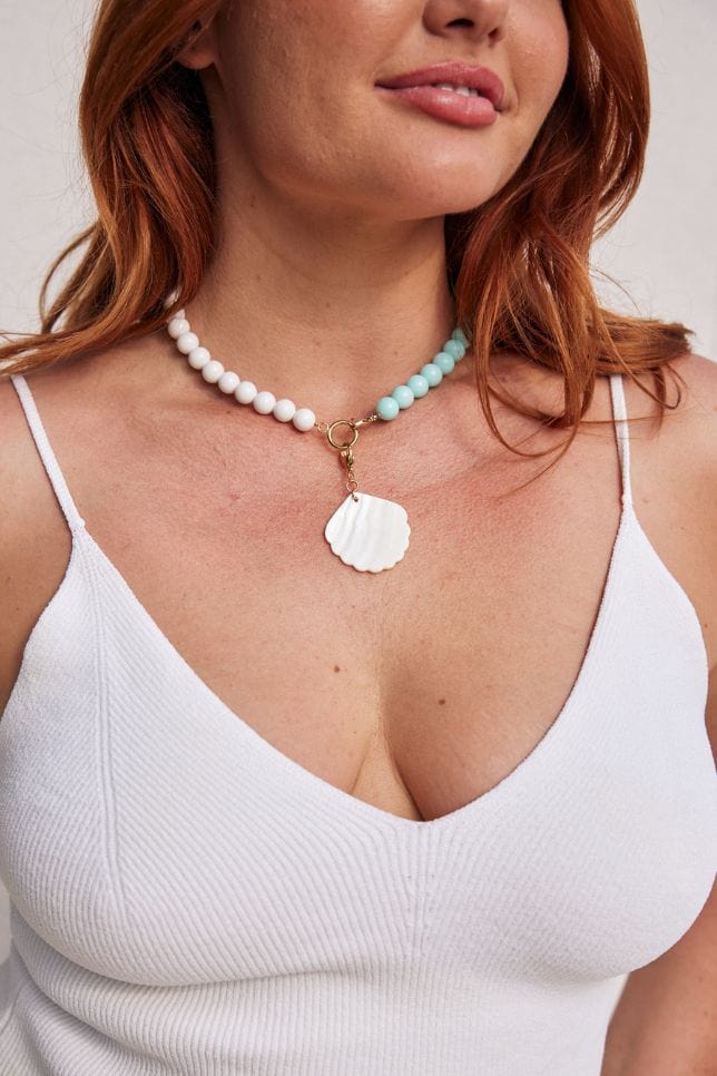 Close up image of red hair model wearing white bold beaded necklace that is handmade in Australia