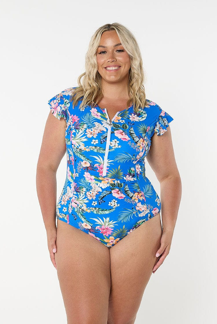 Blonde model wears blue floral flutter sleeve one piece with flattering side panels and stomach ruching