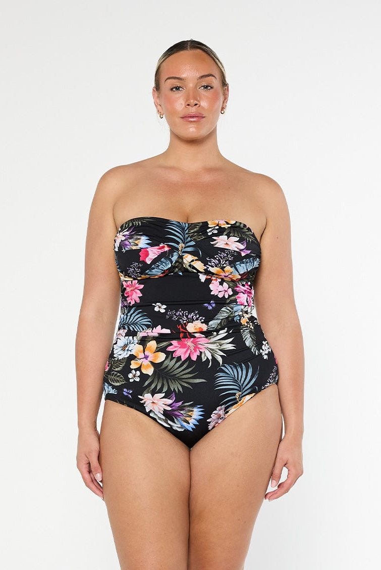 Blonde model wears black floral strapless one piece in chlorine resistant fabric