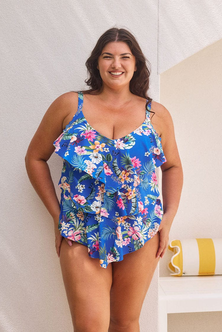 Brunette model wears figure flattering blue floral tankini with 3 tier design for tummy control