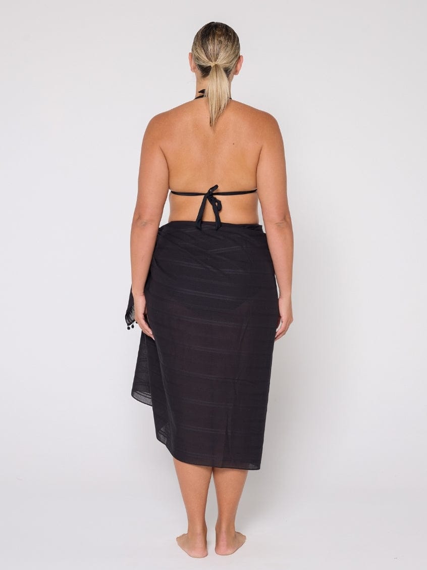Person wearing a black sarong on a white background