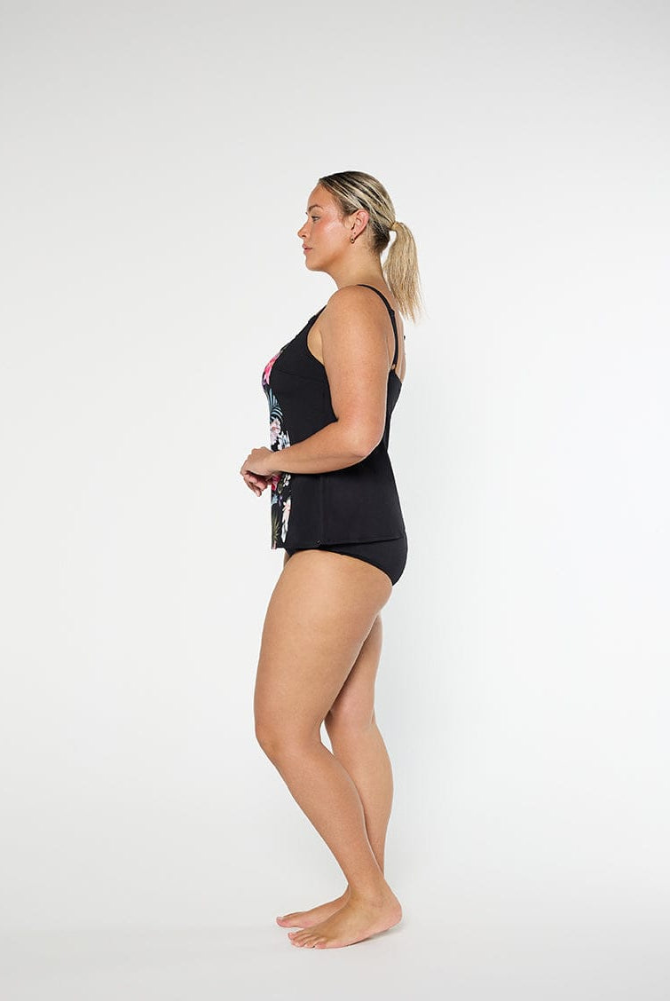 Woman wearing a black swimsuit with floral design on a white background