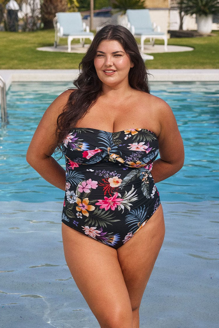 Brunette model wears black floral pool proof bandeau one piece in chlorine resistant fabric