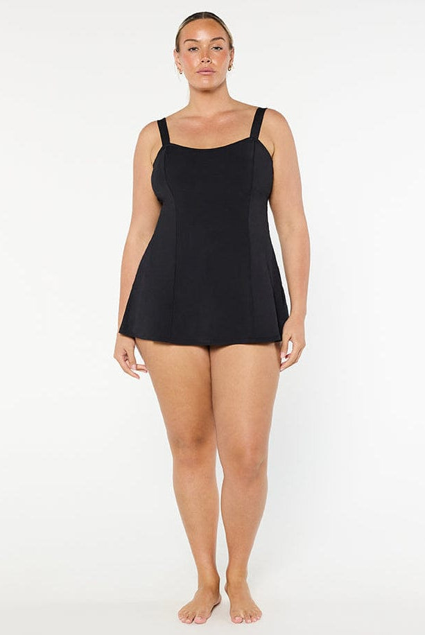 Person wearing a black tank top against a white background