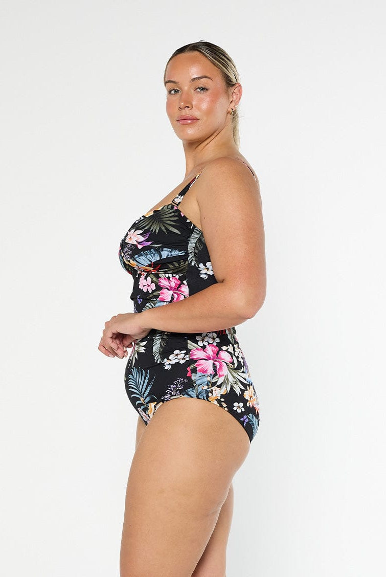 Blonde model wears black floral one piece in pool proof fabric with removable straps