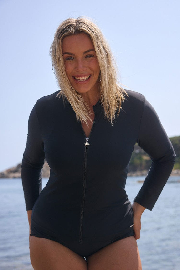 brunette model wears plain black long sleeve rash vest