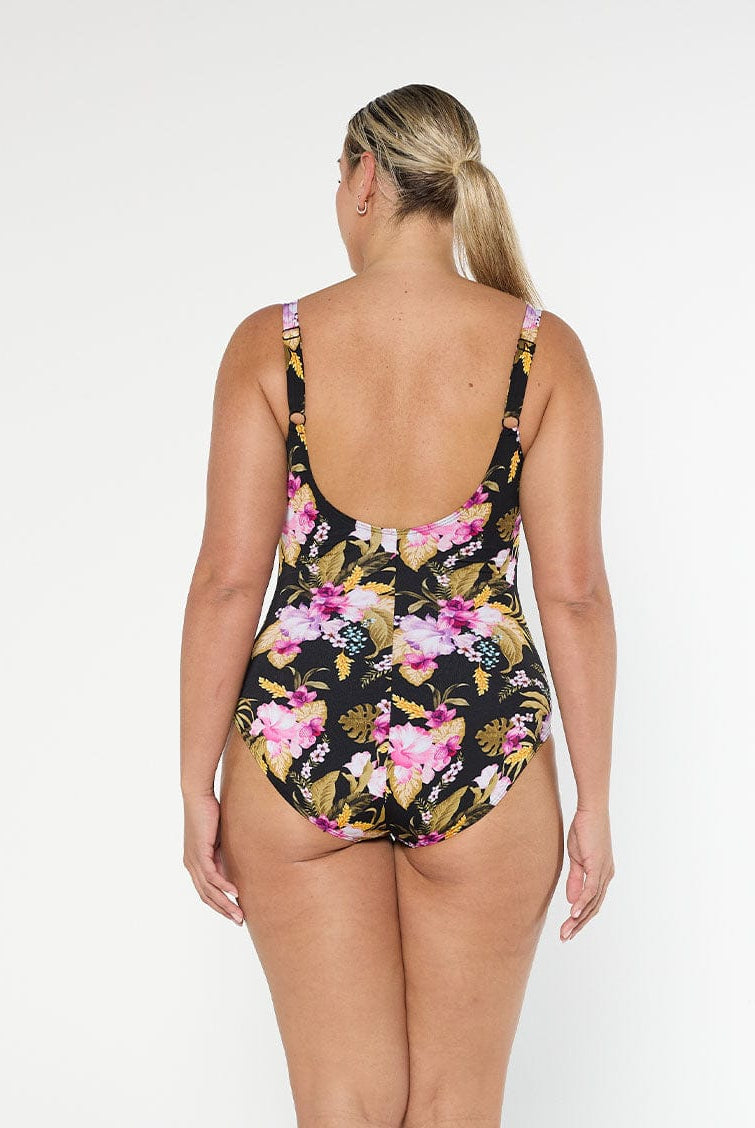Blonde model wears low scoop back one piece with pink and gold floral chlorine resistant fabric with adjustable straps