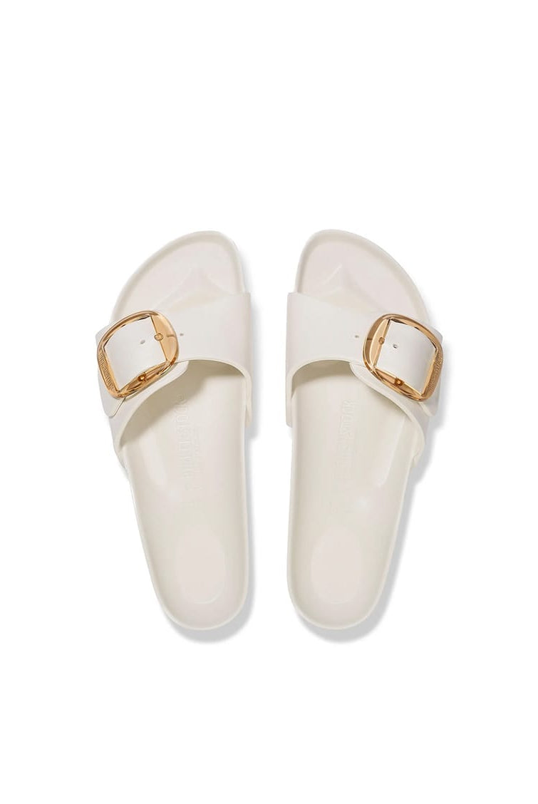 A pair of off-white slide sandals with double straps and gold-tone square buckles, shown from a top-down view on a white background.