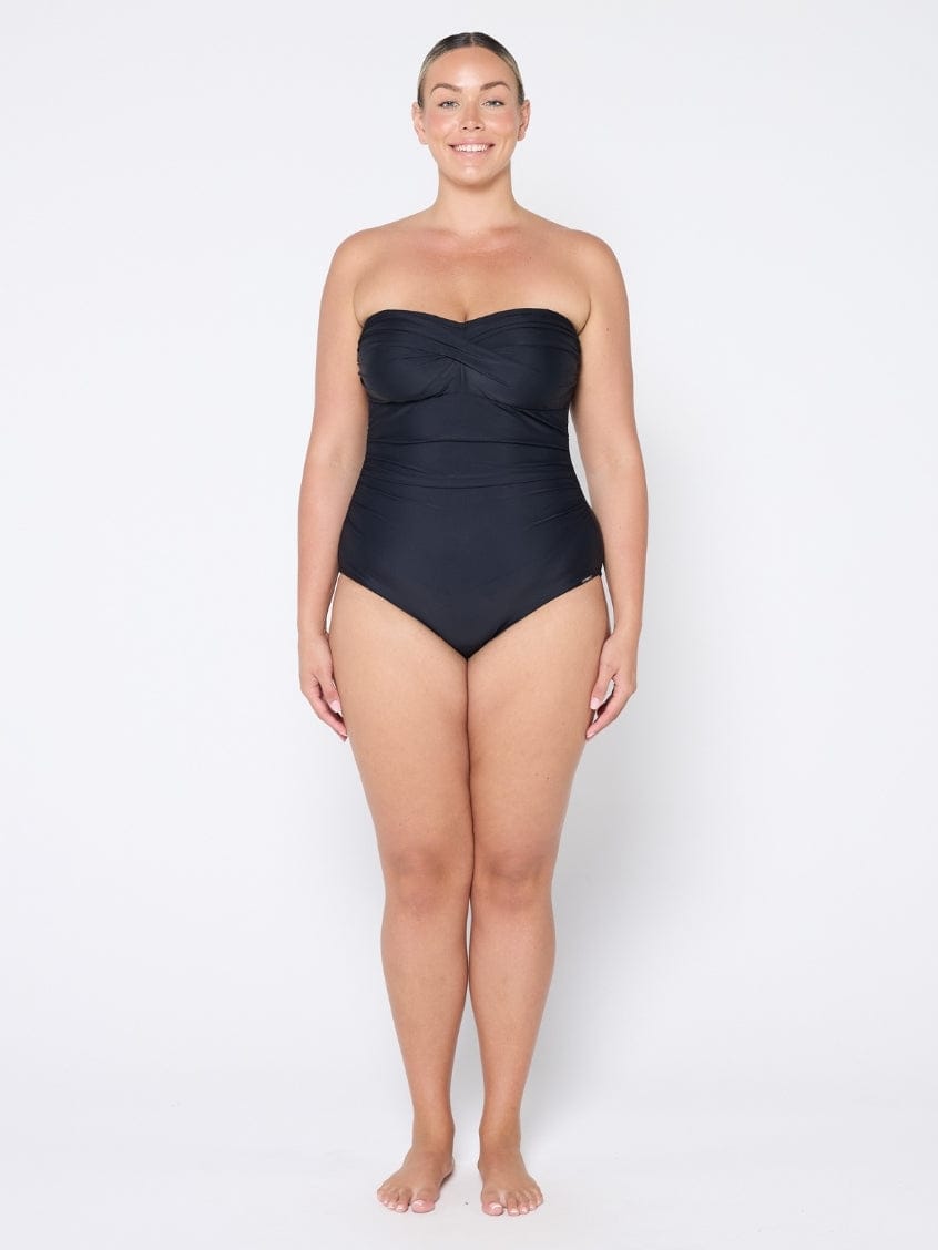 Woman wearing a black strapless swimsuit on a white background