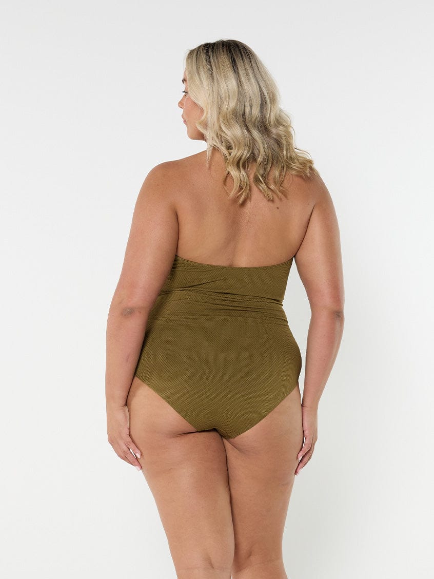 Blonde model wears strapless halter neck one piece in flattering textured olive fabric