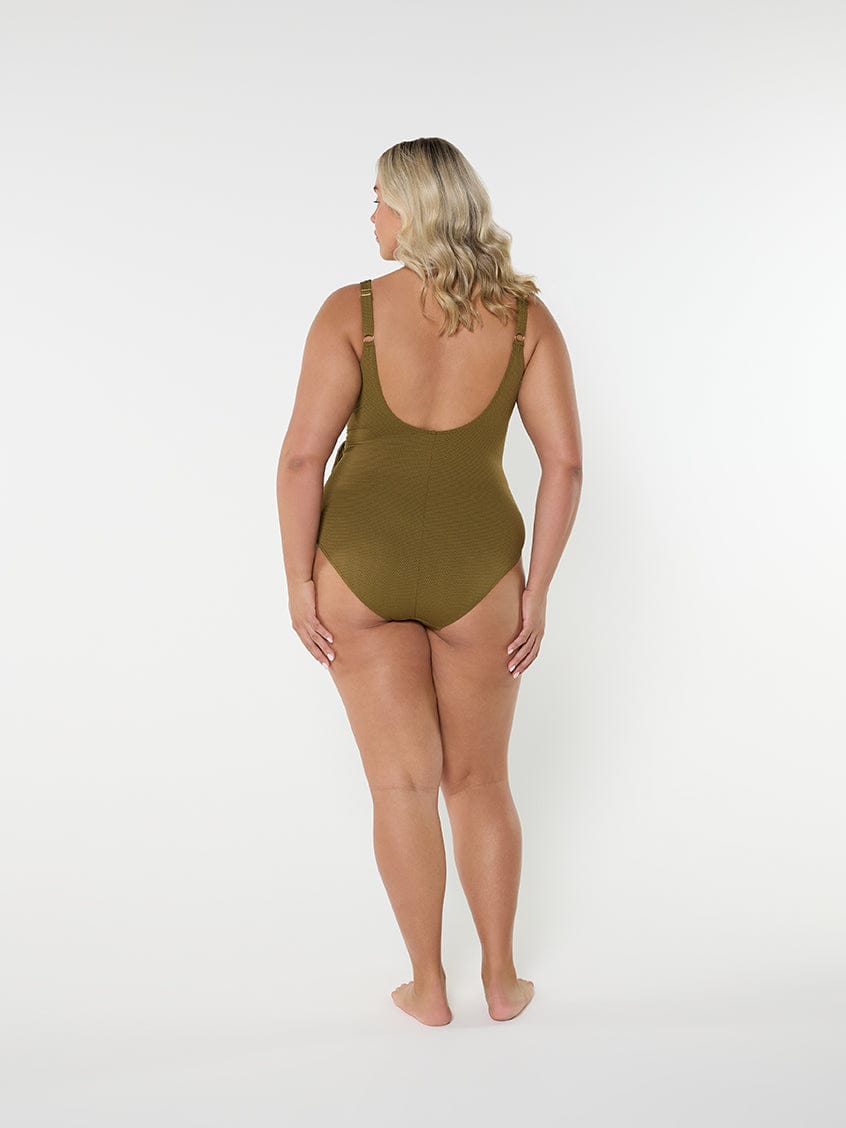 Woman wearing a green swimsuit on a white background