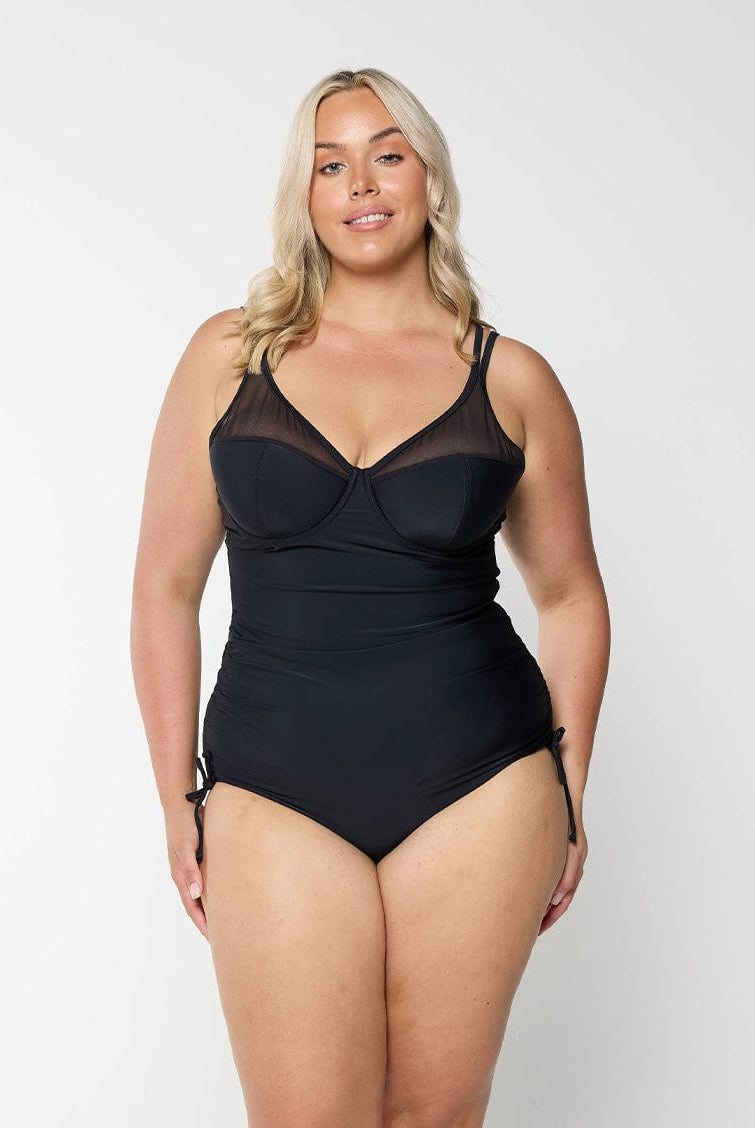 model wearing black mesh one piece with side ruching