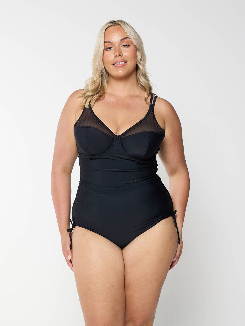 model wearing black mesh one piece with side ruching