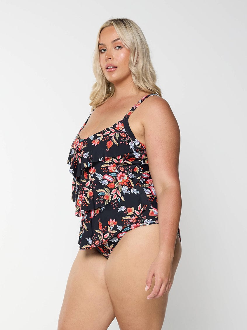 model showing side of black and red floral tiered one piece