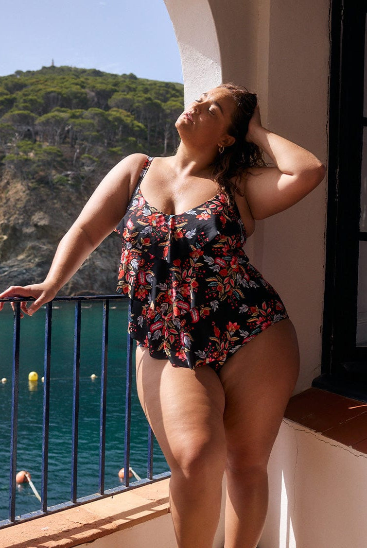 model wearing black and red floral three tier one piece
