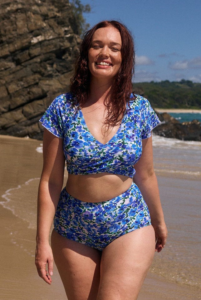 model wearing blue floral wrap bikini on beach