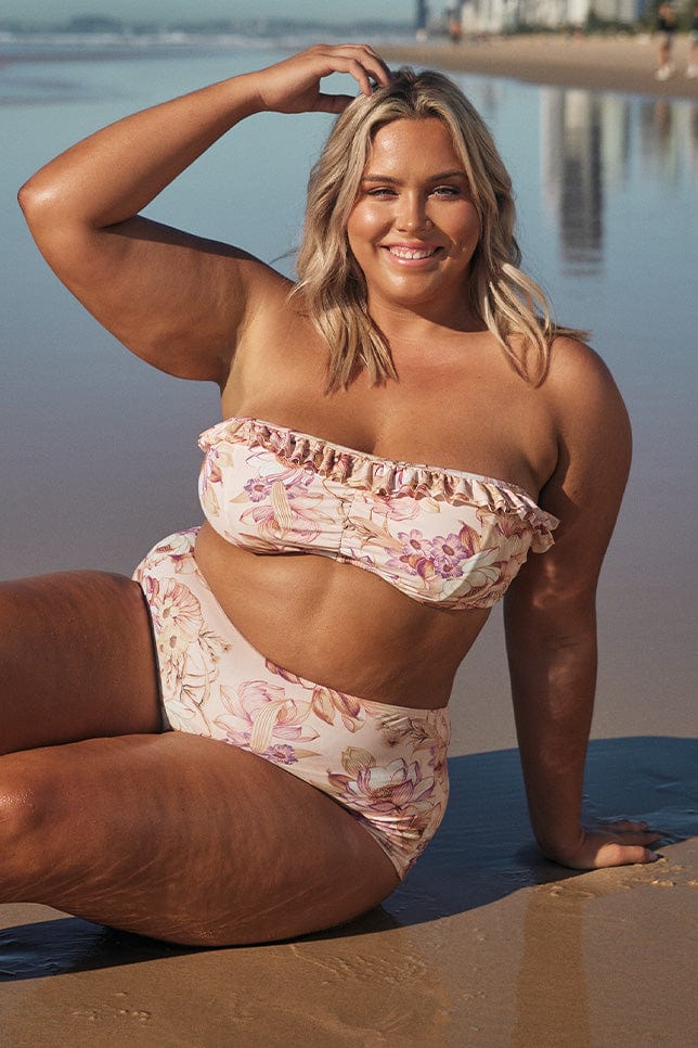 Blonde plus size model wears supportive underwire bandeau bikini top at the beach
