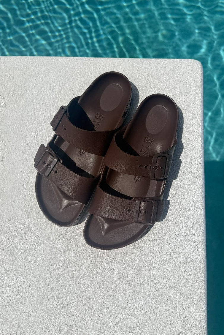 brown sandals on a diving board over pool