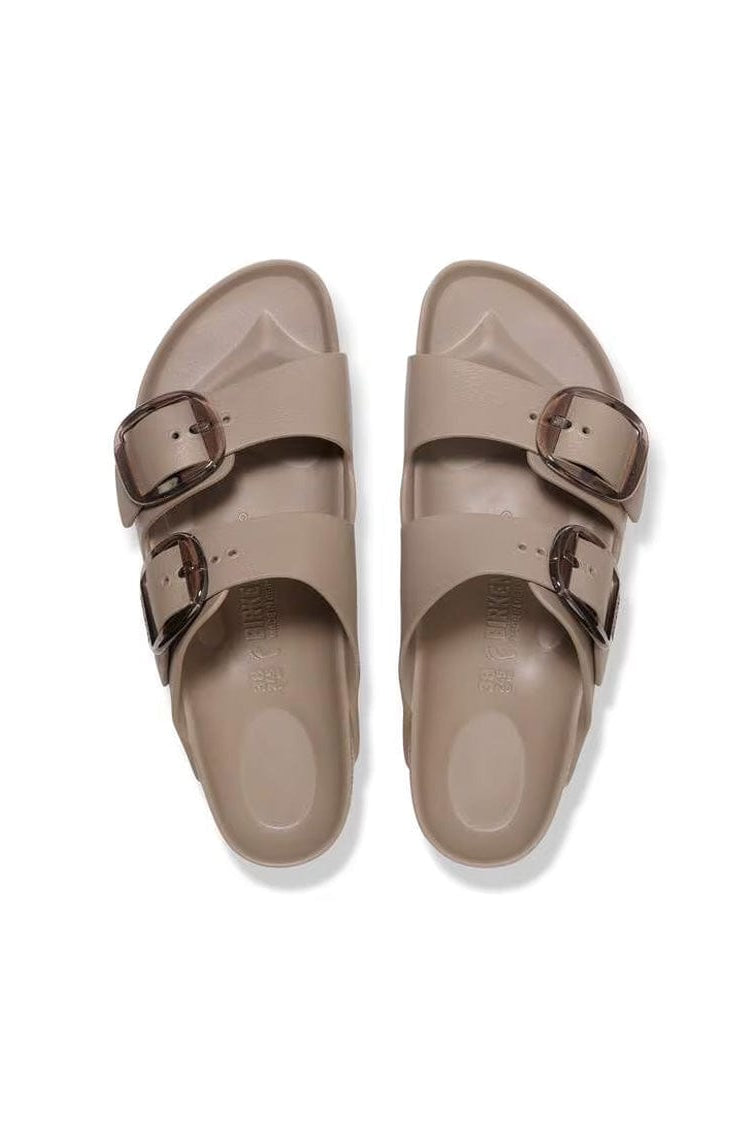 Pair of beige sandals with double buckles on a white background