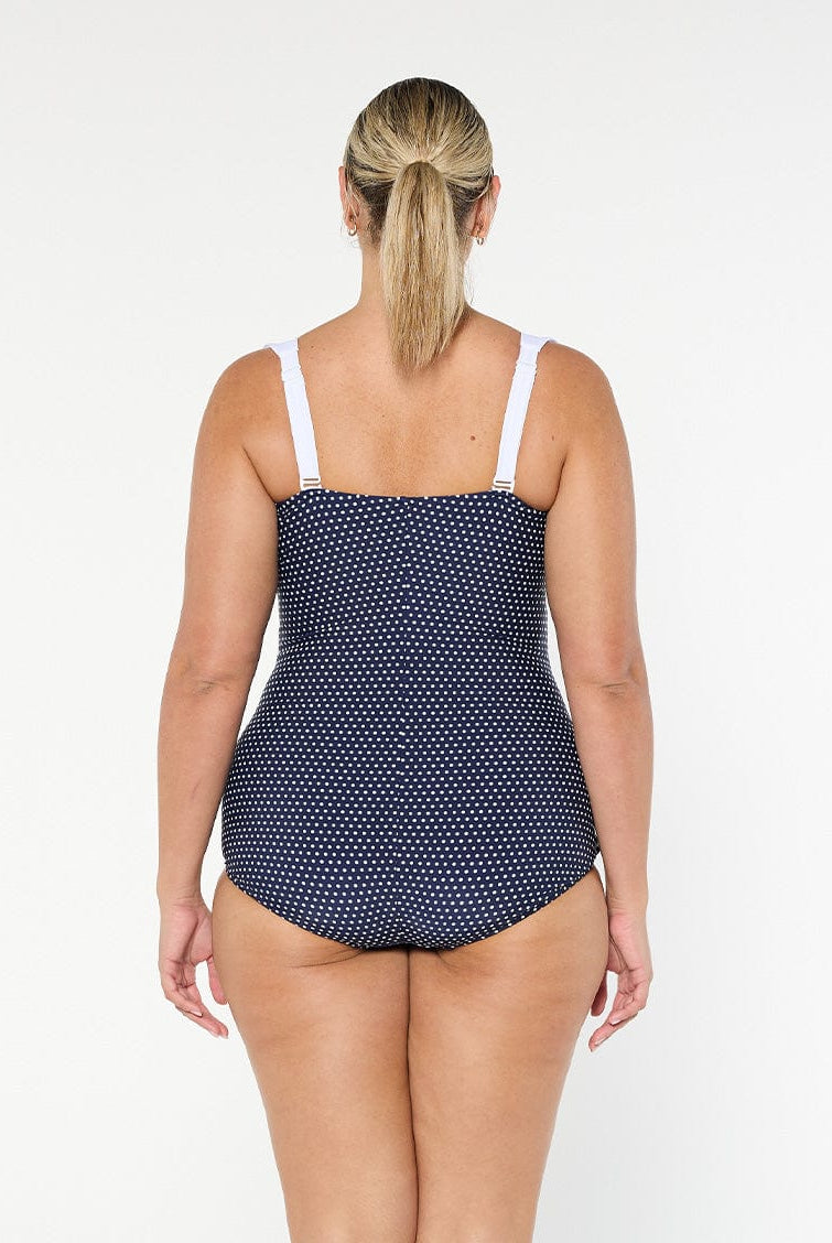 model showing back of navy and white dots retro inspired swimsuit