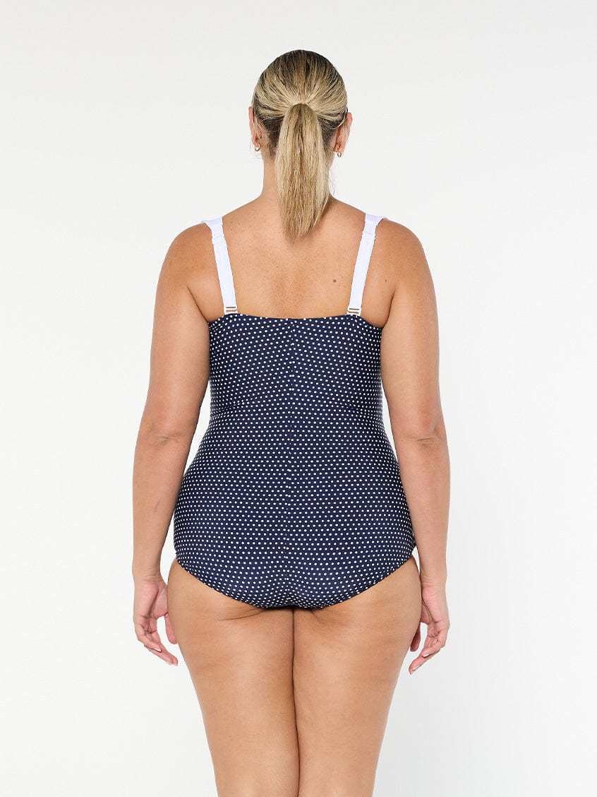 model showing back of navy and white dots retro inspired swimsuit