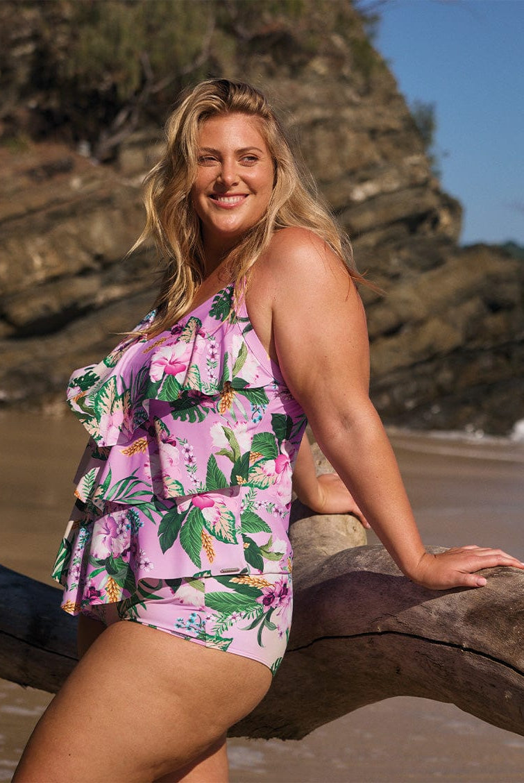 model wearing pink floral tankini and pant at beach
