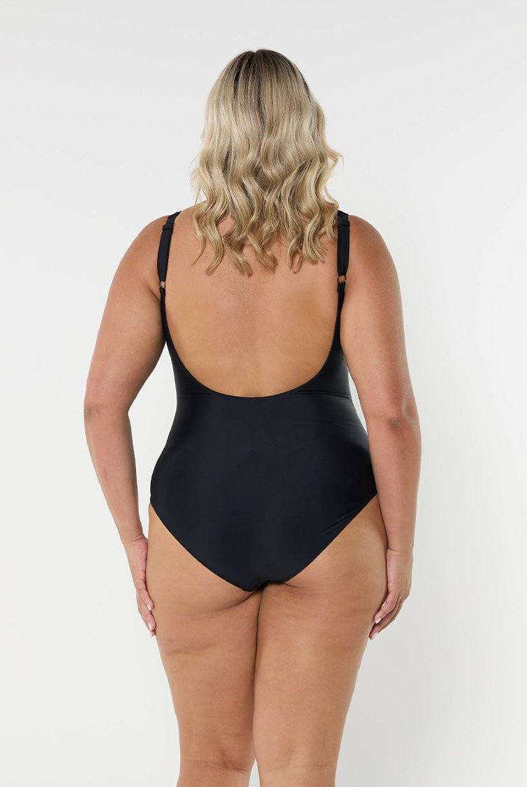 model showing low back of plain black ladies swimsuit