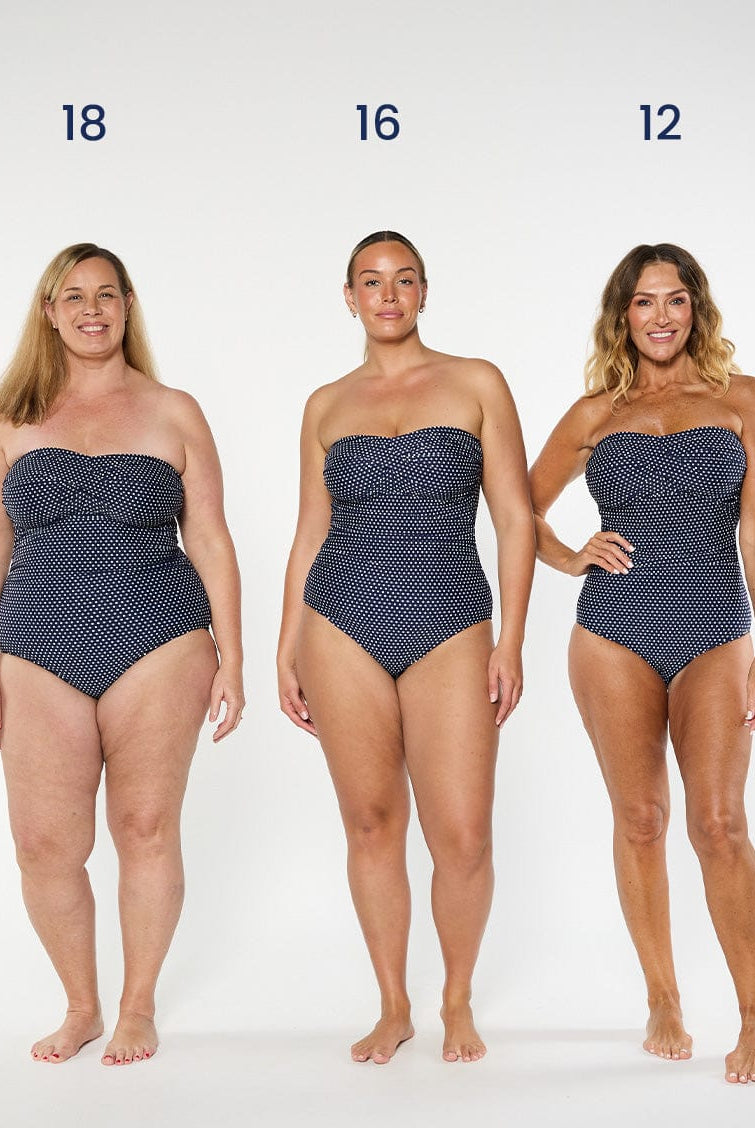 three models wearing navy polka dot strapless swimsuit