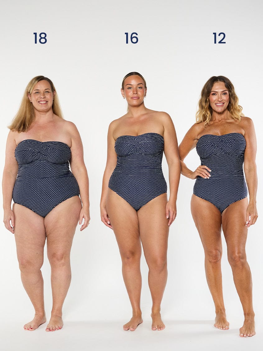 three models wearing navy polka dot strapless swimsuit