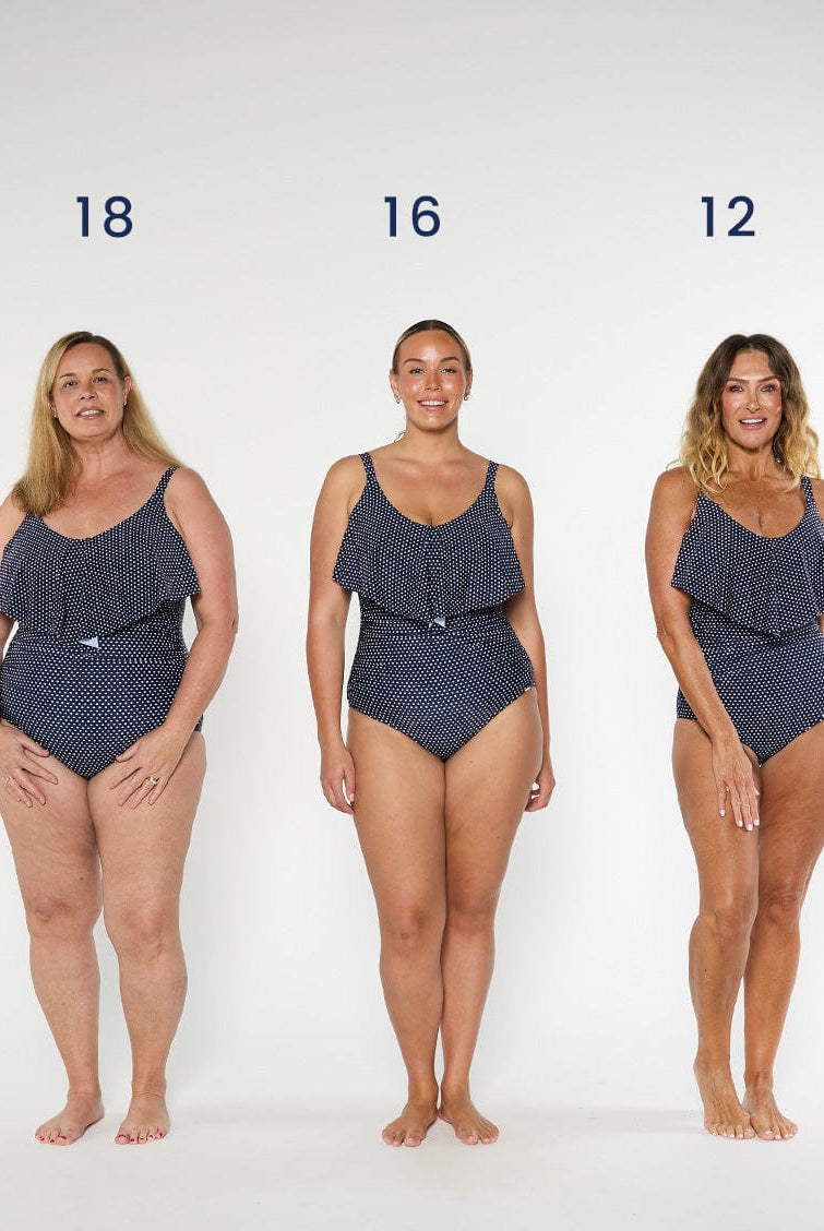 three models wearing navy and white dots swimsuit