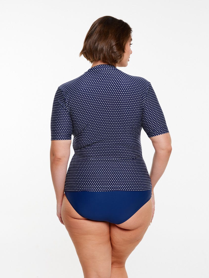 model showing back of navy polka dot rash vest