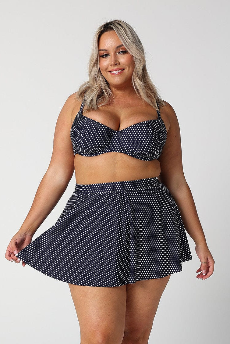 model wearing navy polka dot skater skirt with matching top