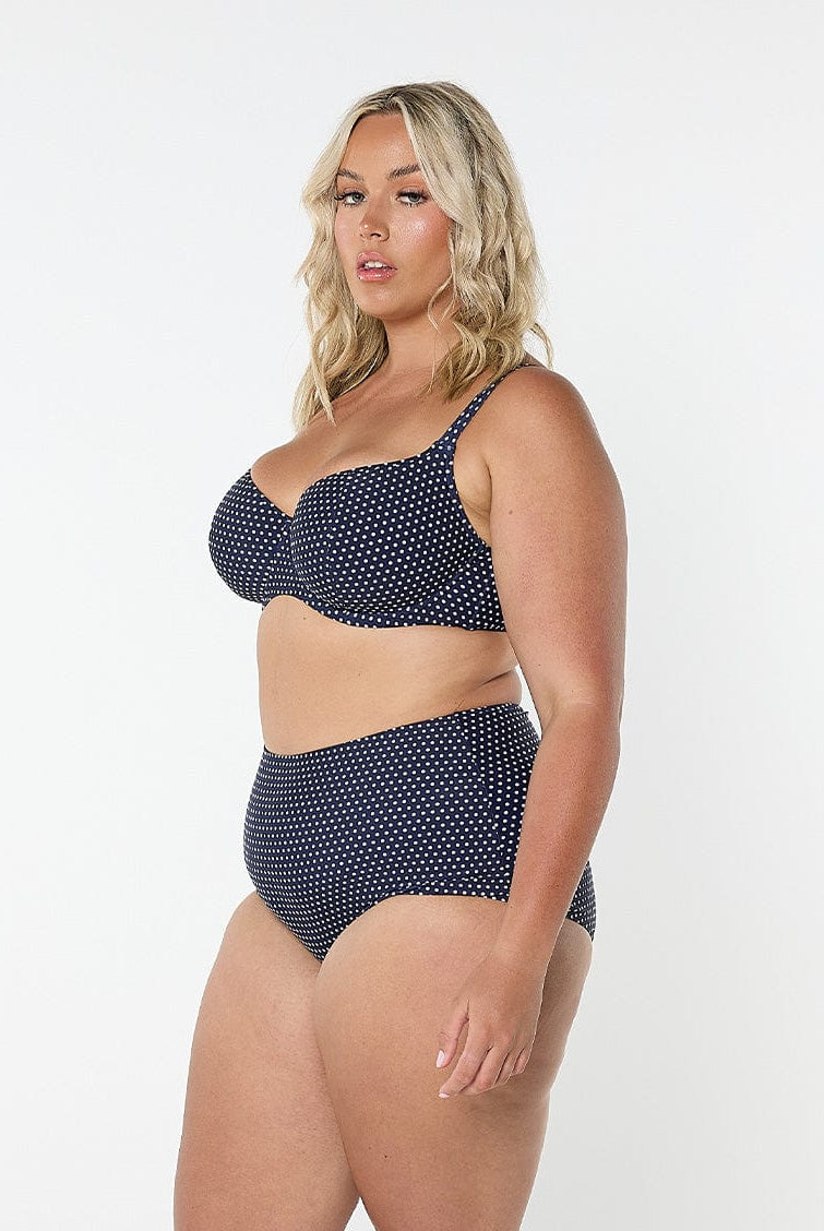 model showing side of navy polka dot high waisted bikini bottom