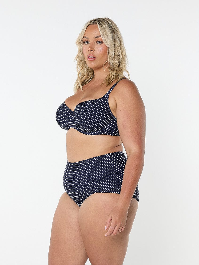 model showing side of navy polka dot high waisted bikini bottom