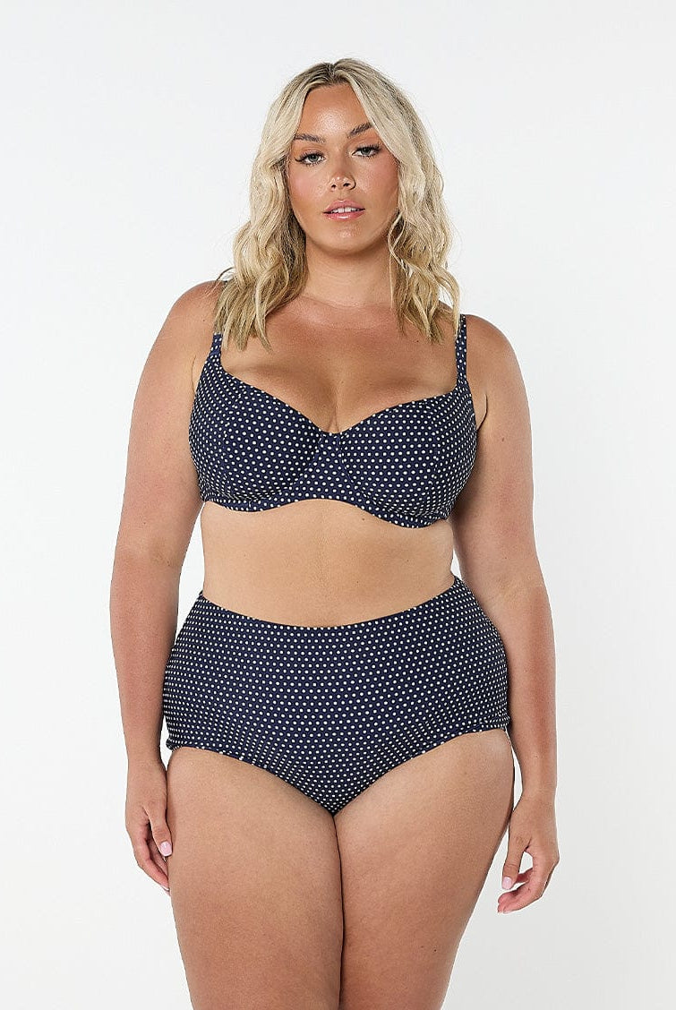 model wearing navy and white polka dot underwire bikini top
