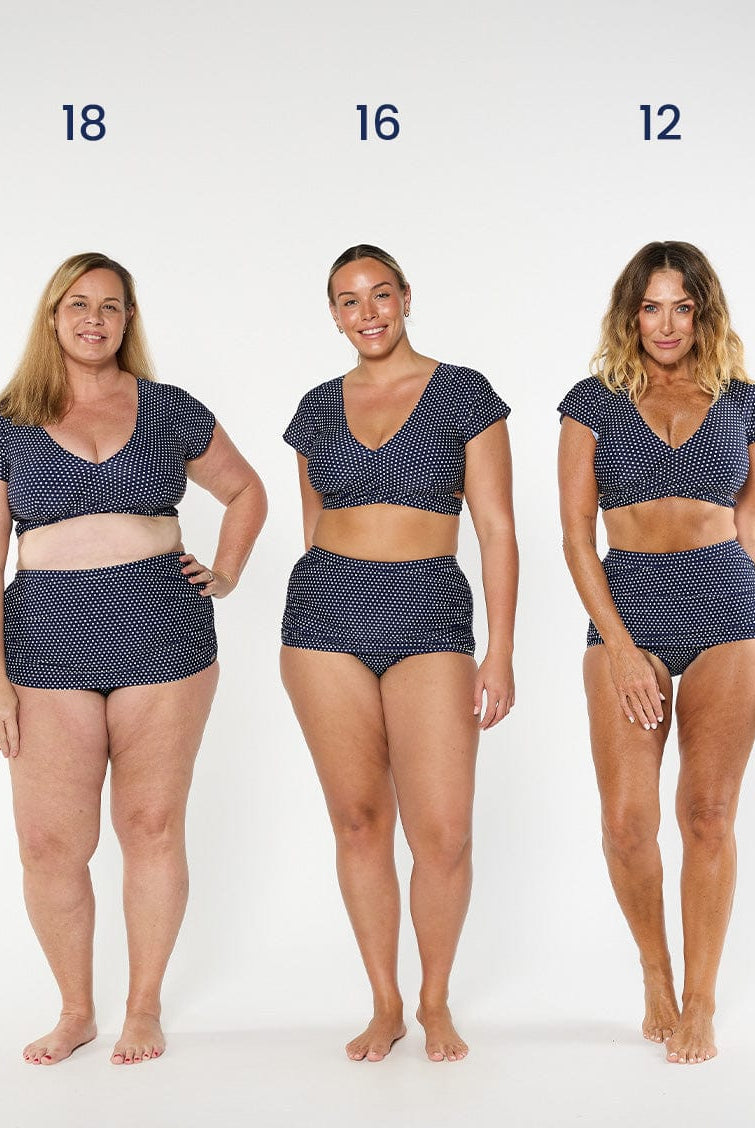 three models wearing navy and white dots wrap crop top and matching skirted pant