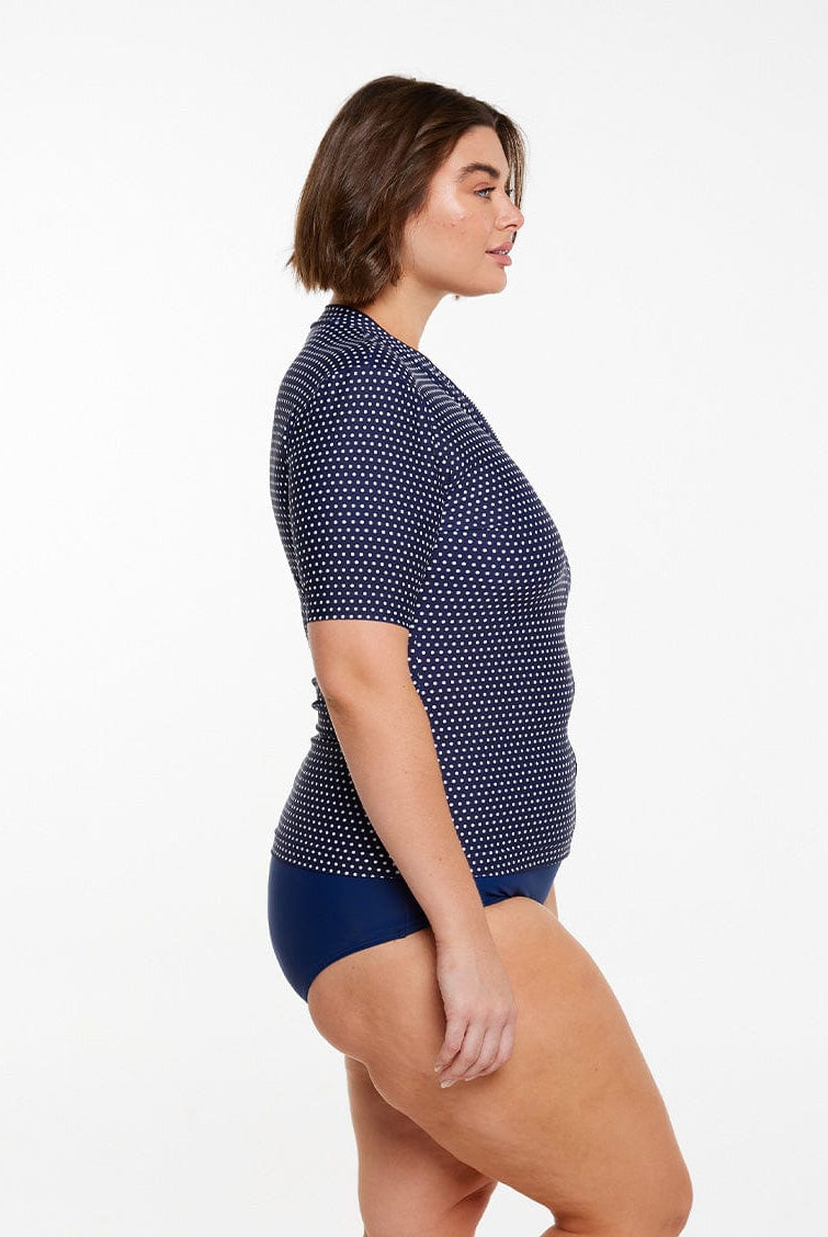 model showing side of navy polka dot rash vest