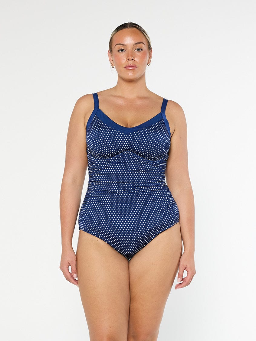 model wearing navy and white dots underwire swimsuit
