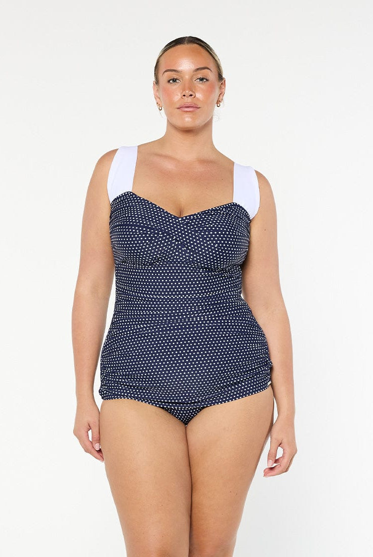 model wearing navy and white dots retro inspired one piece