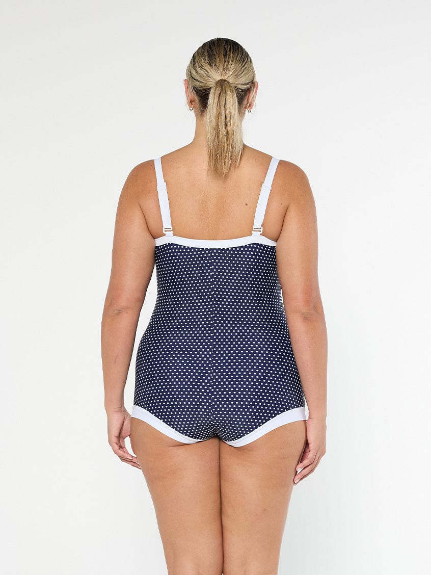 model showing back of navy polka dot boyleg one piece