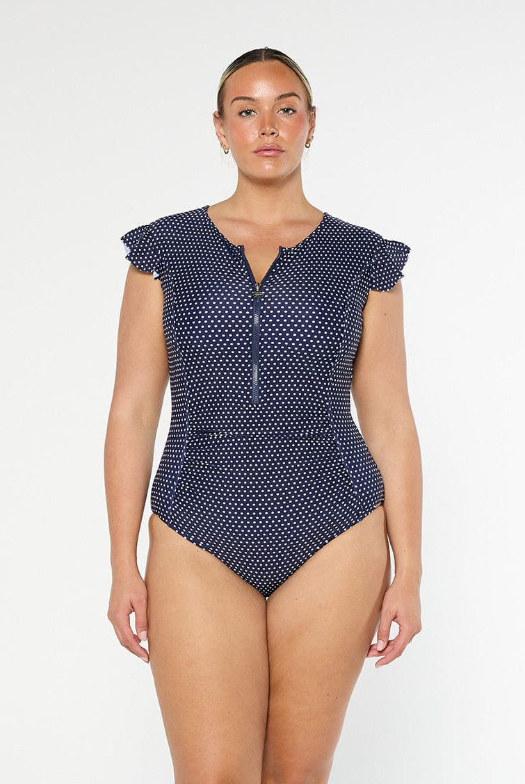 model wearing navy and white dots frill sleeve one piece