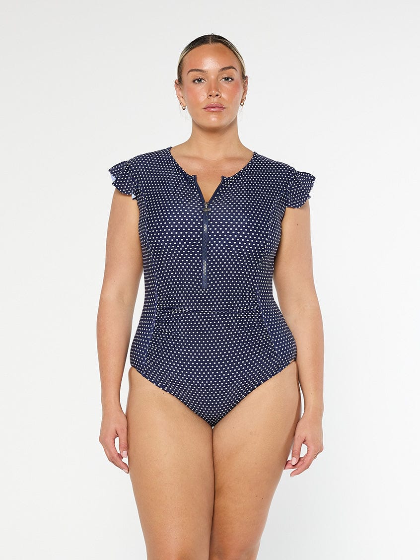 model wearing navy and white dots frill sleeve one piece