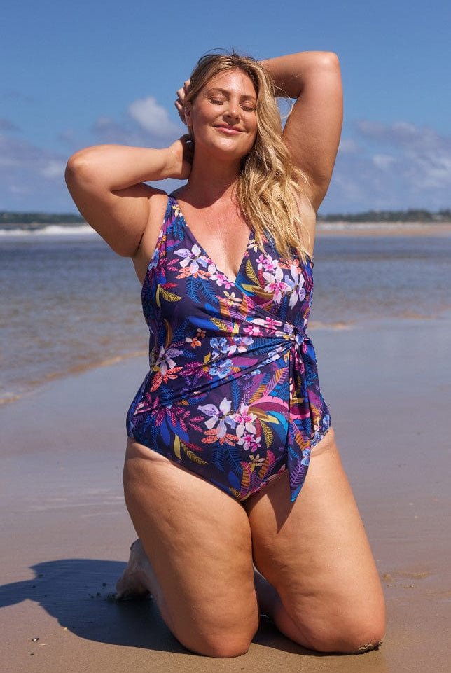 model wearing navy tropical print waist tie swimsuit at beach