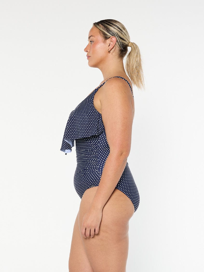 model showing side of navy and white dots women's swimsuit