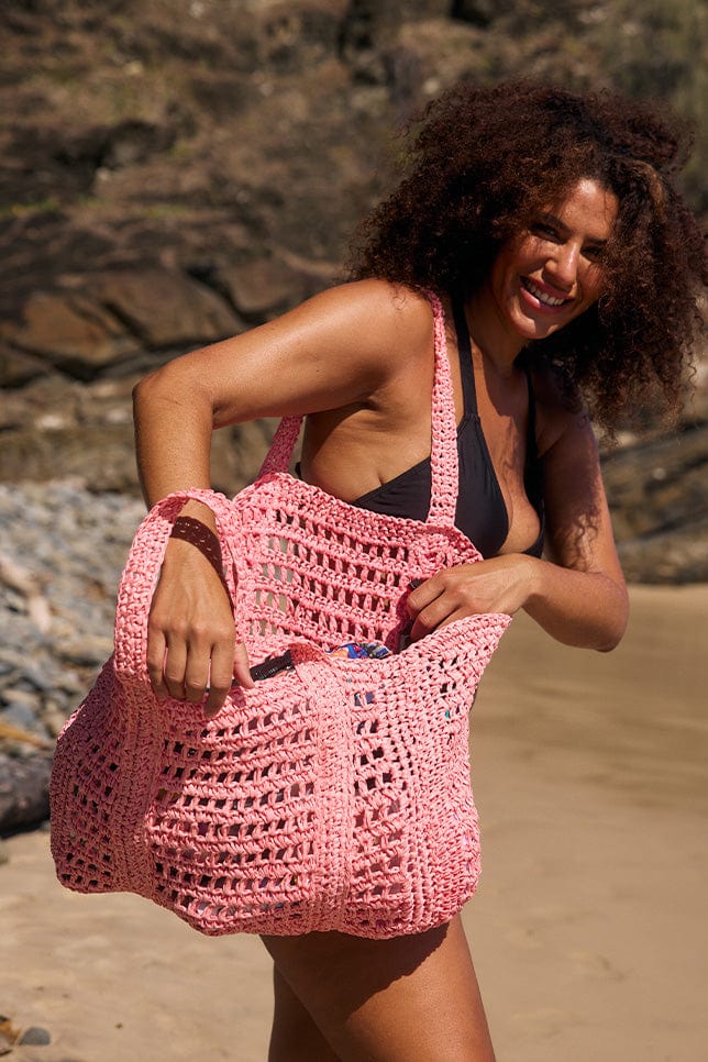 model opening pink woven bag