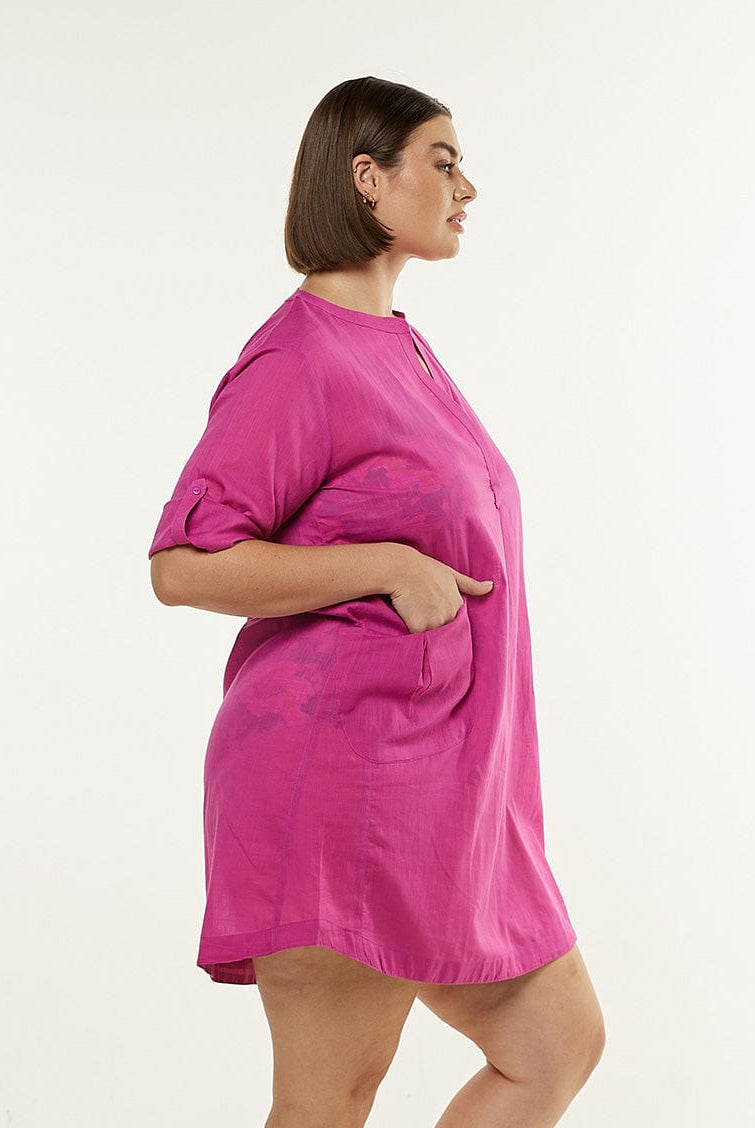 Model wearing pink beach dress with button up sleeves