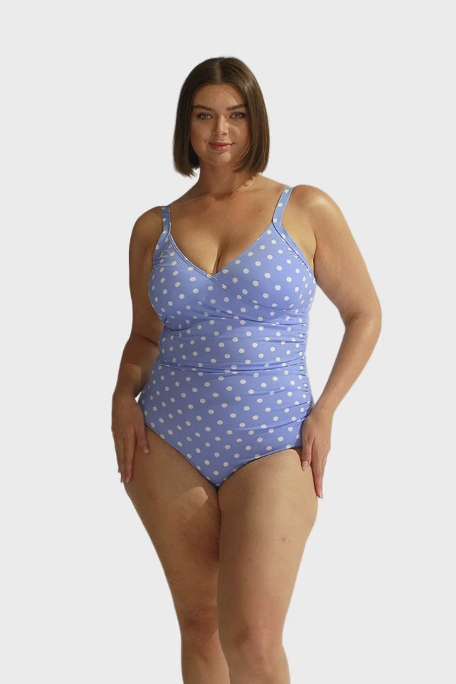 Model wearing light blue with white dots crossover one piece swimsuit
