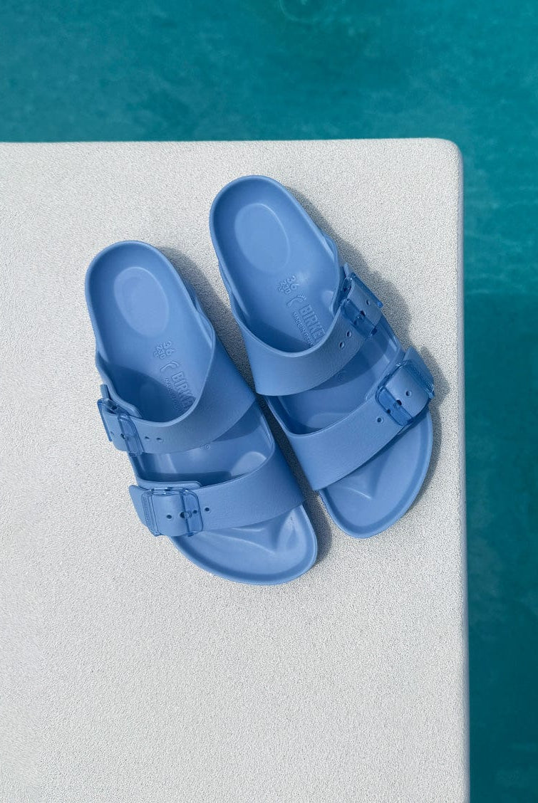Blue sandals on a diving board over pool