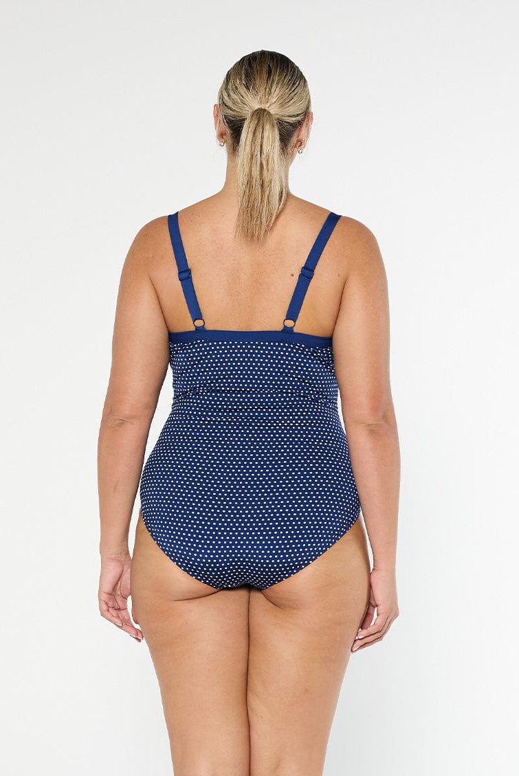model showing back of navy polka dot one piece